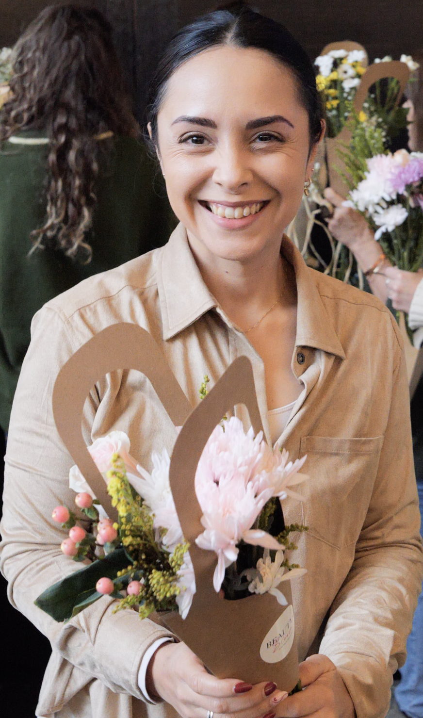 Colaboradora sonriendo con su composición floral